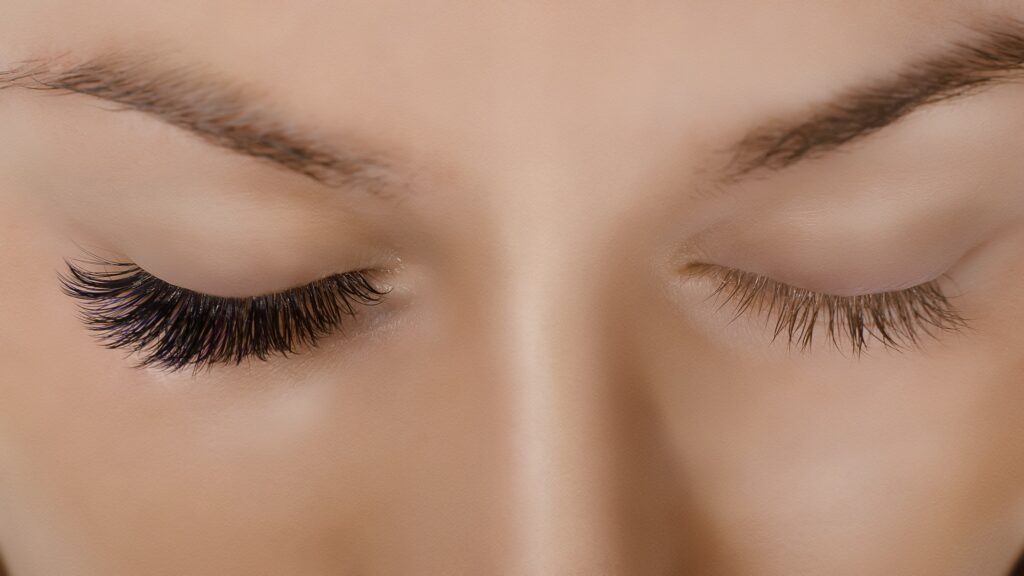 Eyelash Extension Procedure. Close up view of beautiful female eye with long eyelashes, smooth
