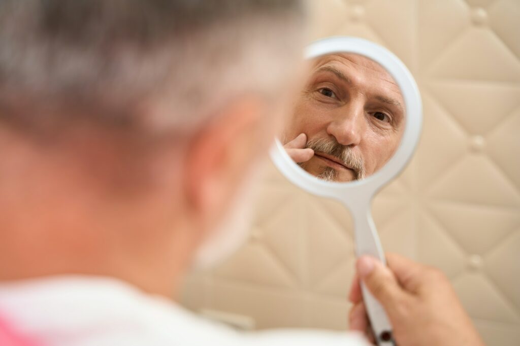 Man sitting in front of mirror skin care cosmetics